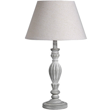 Hand-carved wooden table lamp with linen shade in warm beige, showcasing artisanal craftsmanship and neutral versatility. by Hill Interiors at brixbailey.com