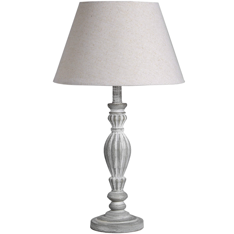 Hand-carved wooden table lamp with linen shade in warm beige, showcasing artisanal craftsmanship and neutral versatility. by Hill Interiors at brixbailey.com