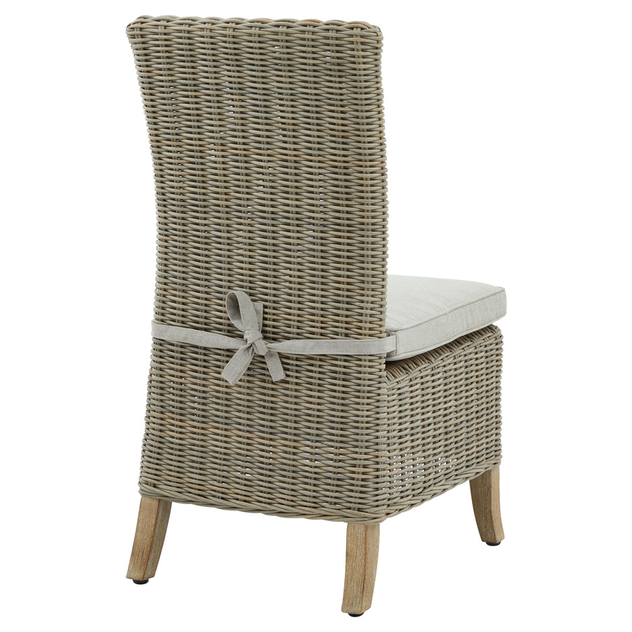 Beige Capri outdoor dining chair with HDPE wicker, aluminum frame, and acacia wood feet, includes Olefin cushion. by Sostter at brixbailey.com