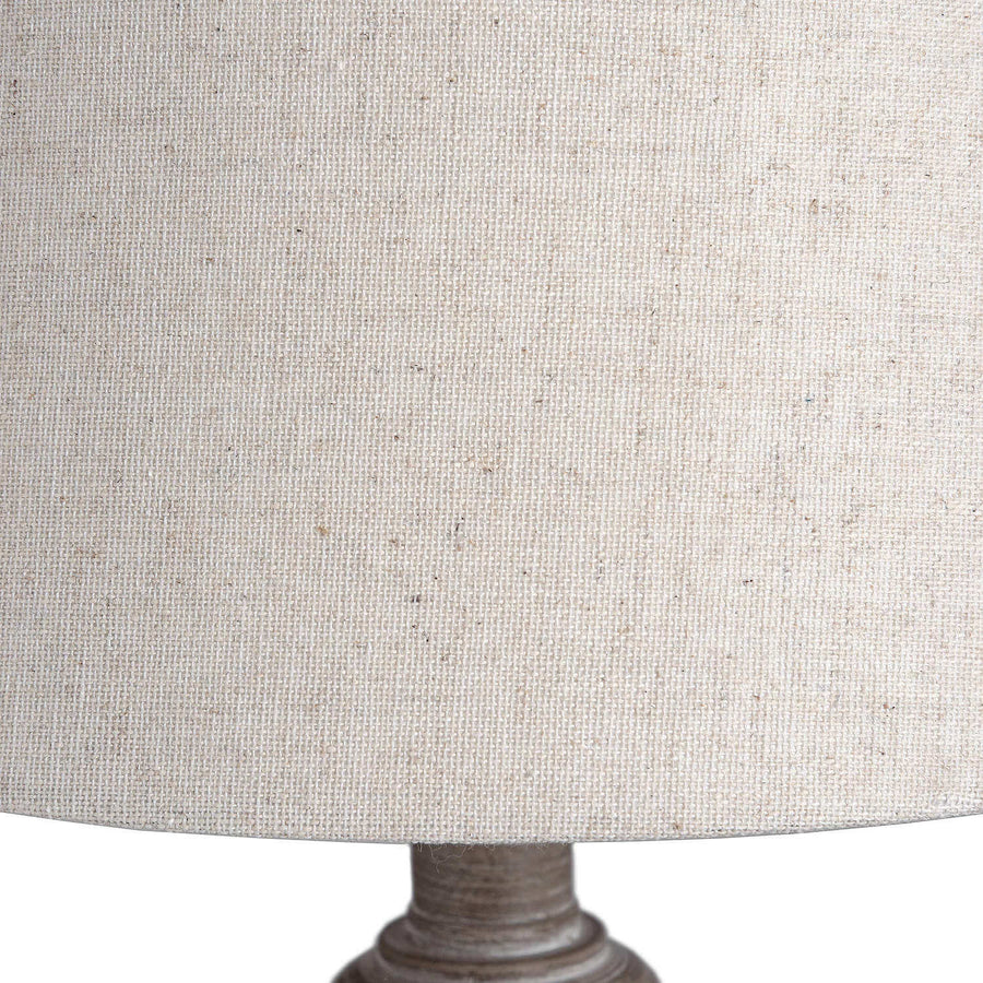Rustic table lamp with whitewashed wood base and linen shade, warm beige tones for cozy ambient lighting. by Hill Interiors at brixbailey.com