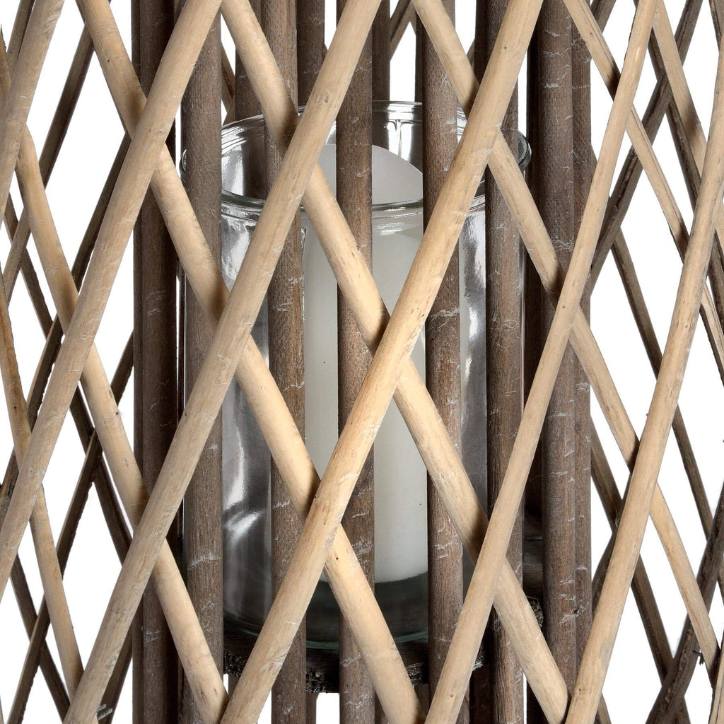 Handwoven rattan lantern with intricate natural weave, rich brown color, casting warm light patterns for indoor or outdoor decor. by Sostter at brixbailey.com