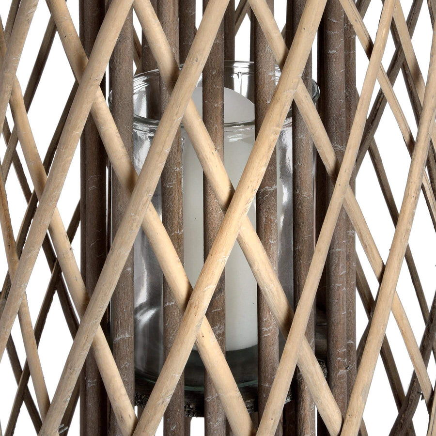 Handwoven rattan lantern with intricate natural weave, rich brown color, casting warm light patterns for indoor or outdoor decor. by Sostter at brixbailey.com