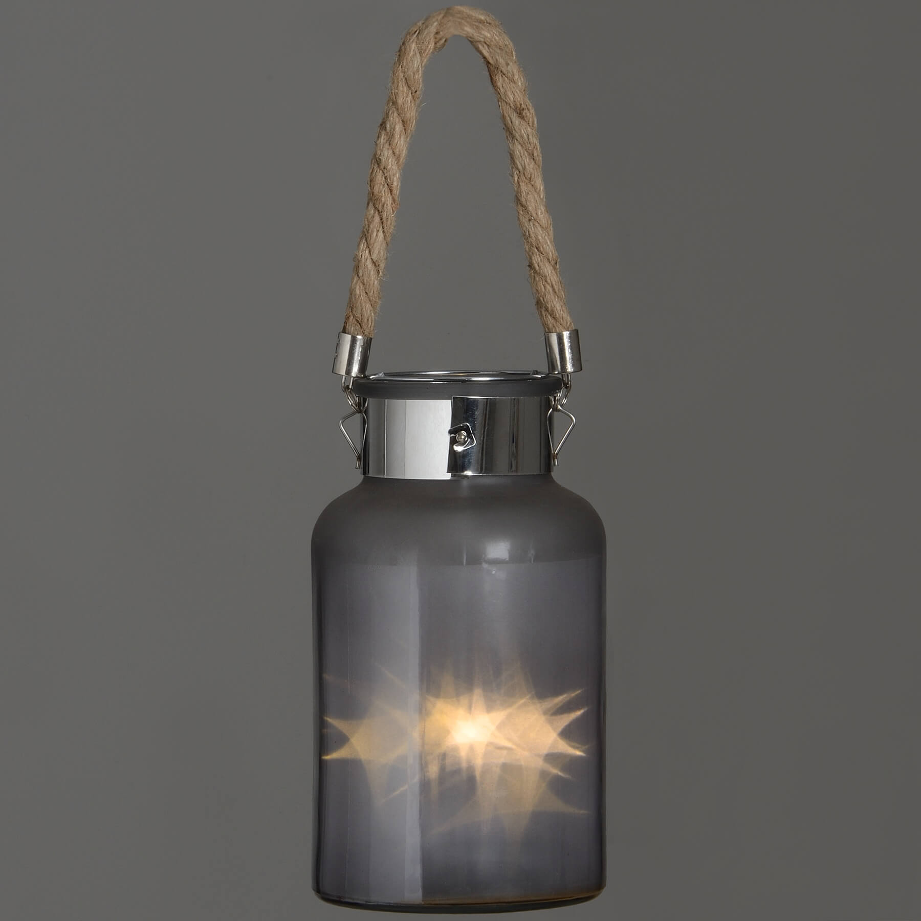 Frosted grey glass lantern with rope handle and warm LED glow, creating a starlight effect for indoor or outdoor decor. by Sostter at brixbailey.com