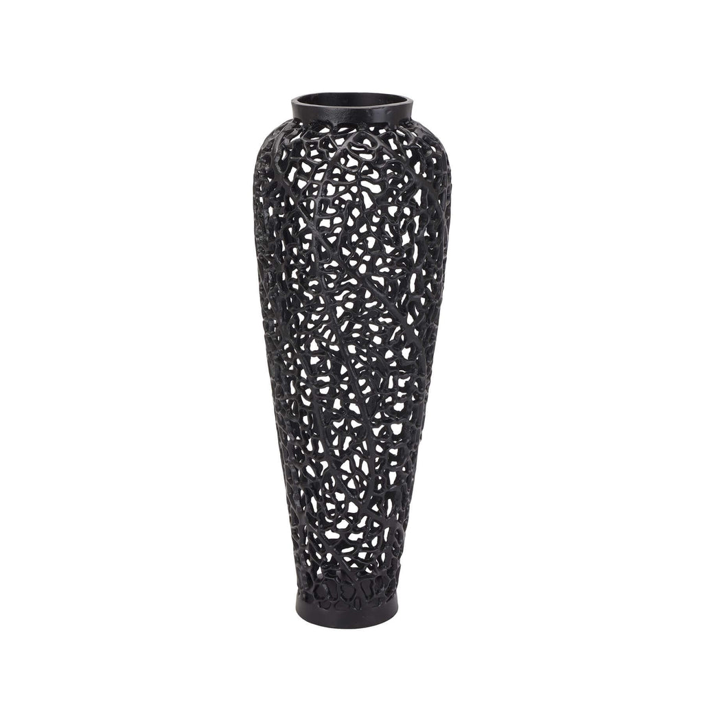 Matte black lattice vase with geometric cutouts, casting dynamic shadows, made of architectural-grade aluminum. by Sostter at brixbailey.com