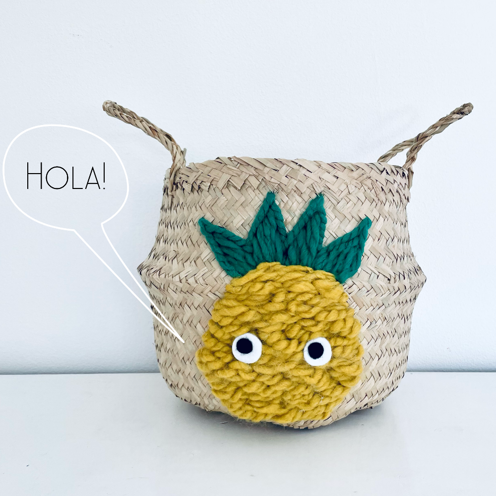 Woven basket with a pineapple decoration on a white background From The Pillow Drop at Sostter