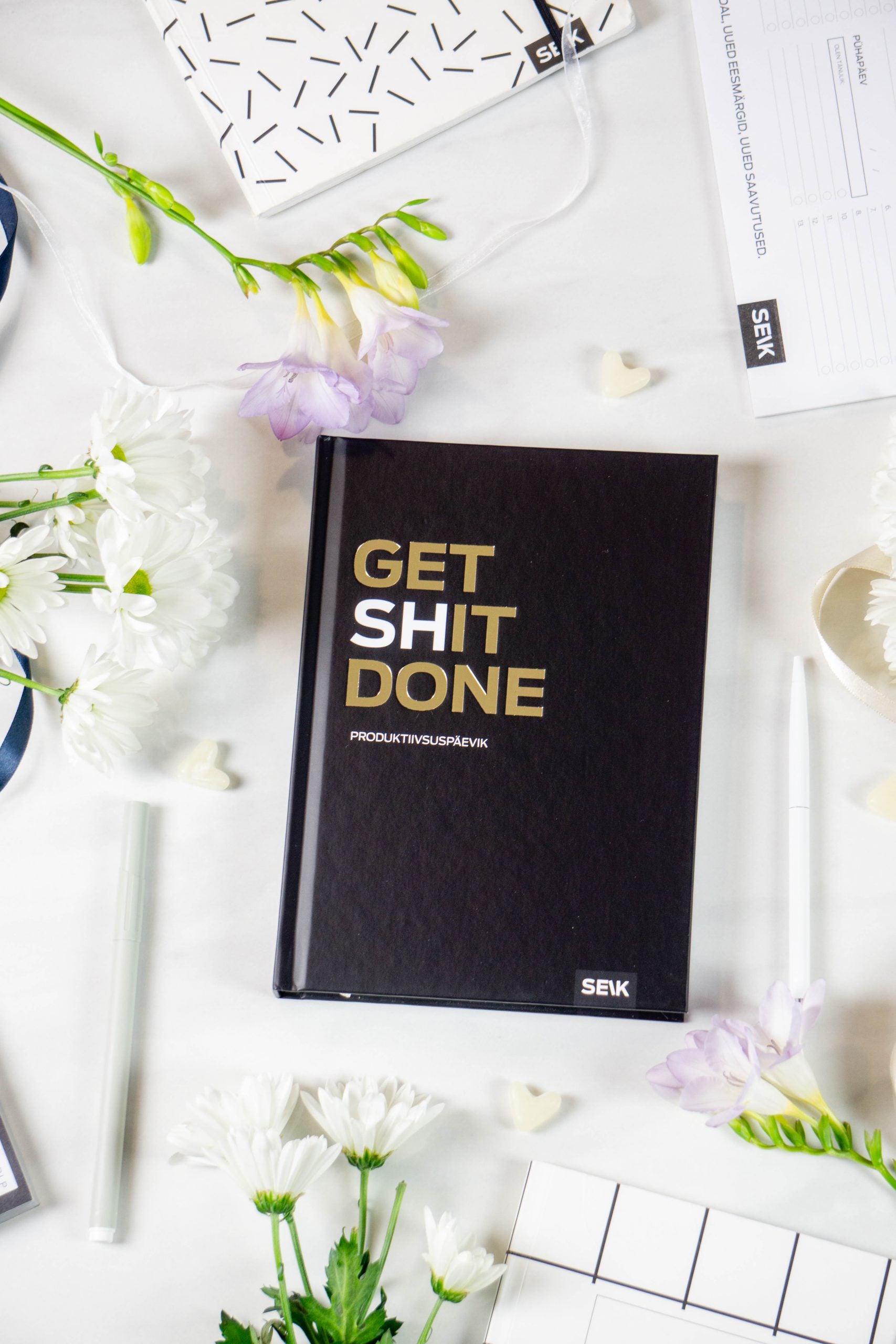 functional productivity planner open on a weekly spread with a pen