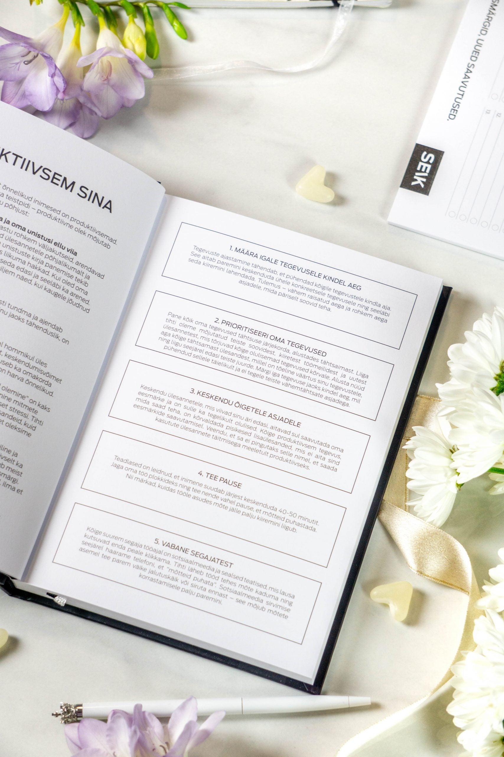 functional productivity planner open on a weekly spread with a pen