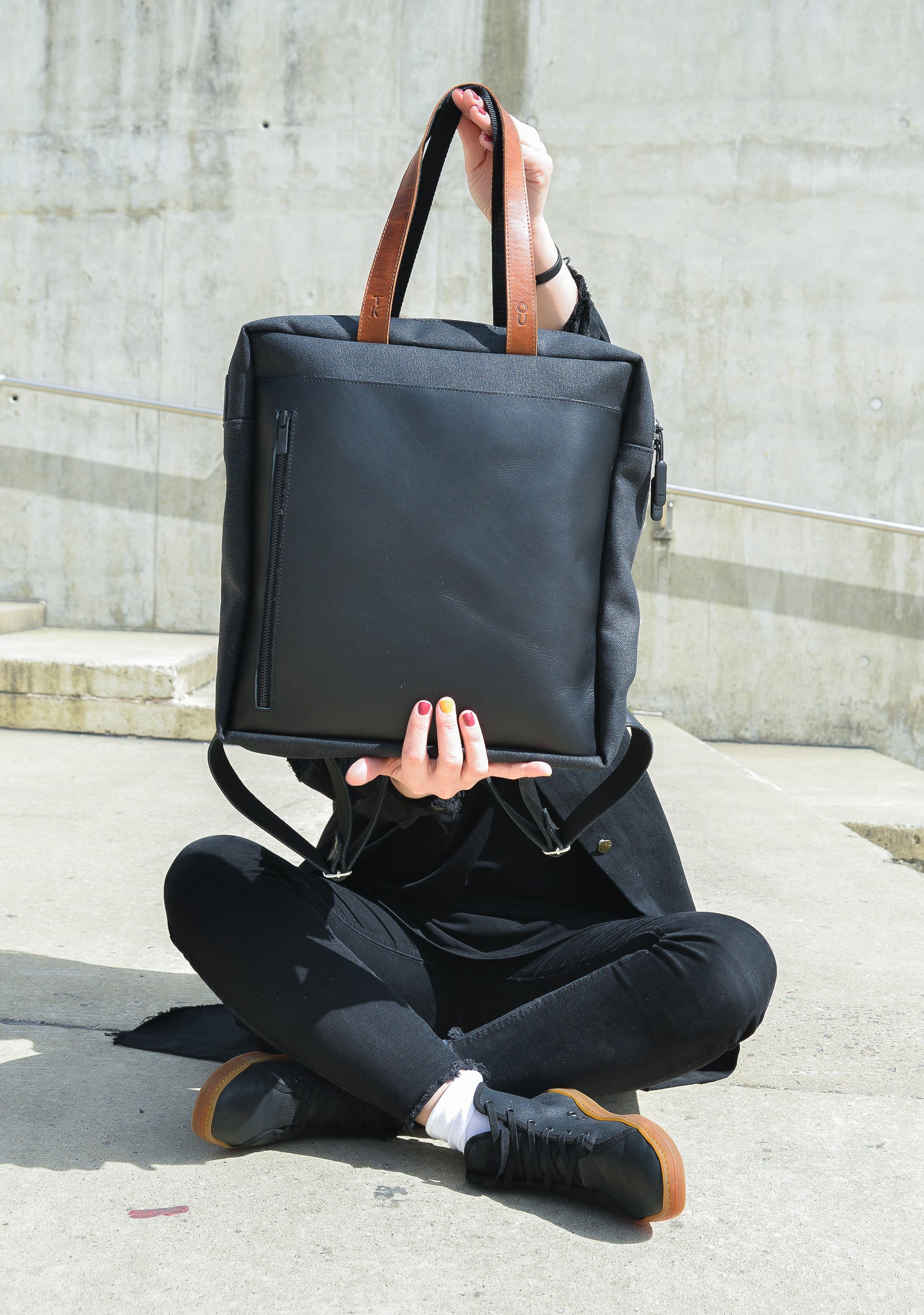 soft beige stockholm backpack with leather accents, open front pocket showing cozy interior, sunlight on fabric