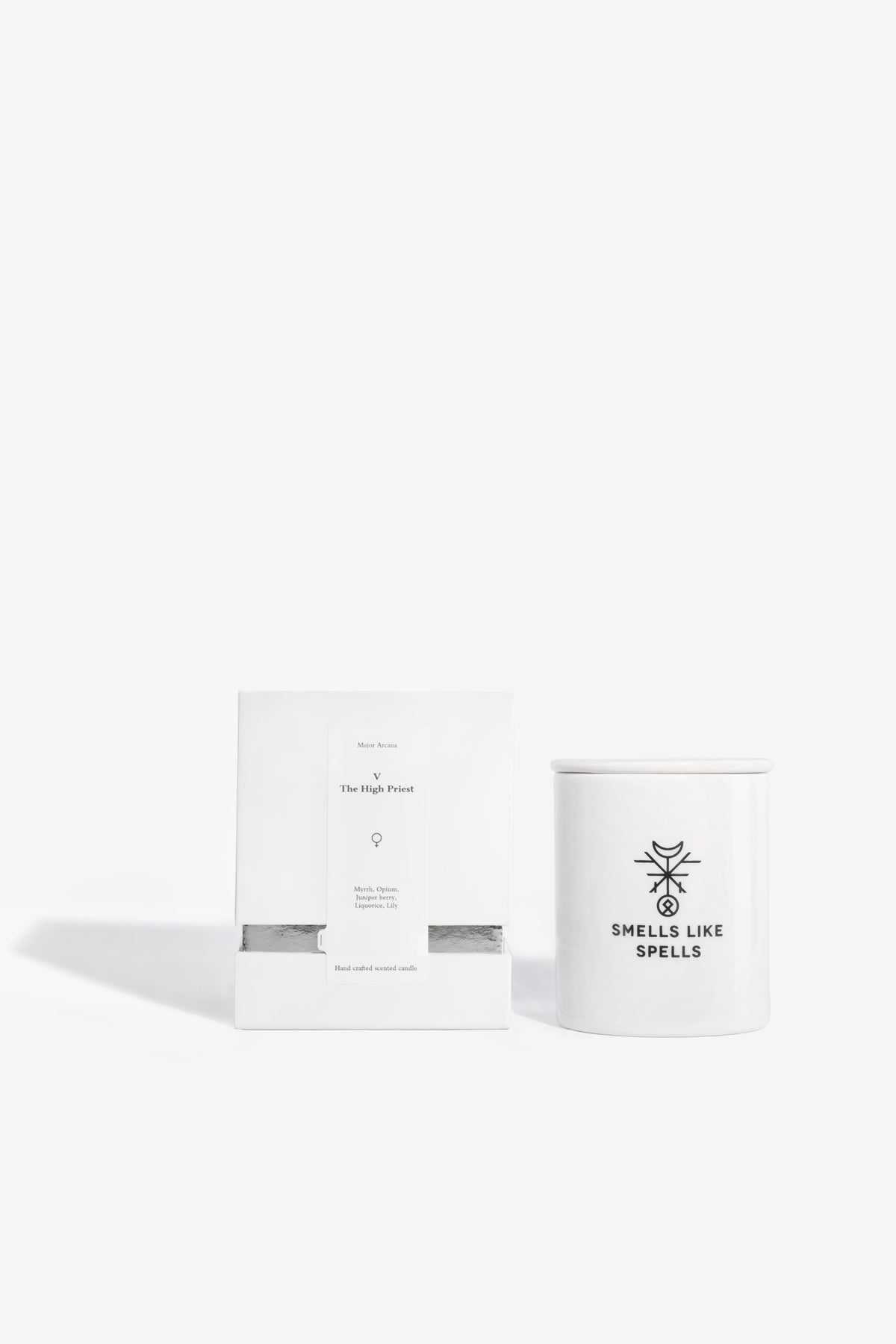 bold close-up of the hierophant soy candle, its porcelain vessel glowing with a warm flame against a dark background