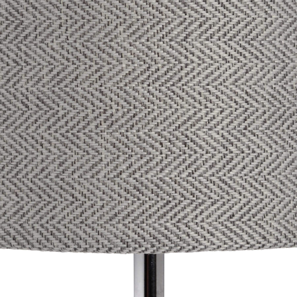Silver designer table lamp with chrome base, glass accents, and herringbone fabric shade for warm ambient lighting by Sostter at brixbailey.com