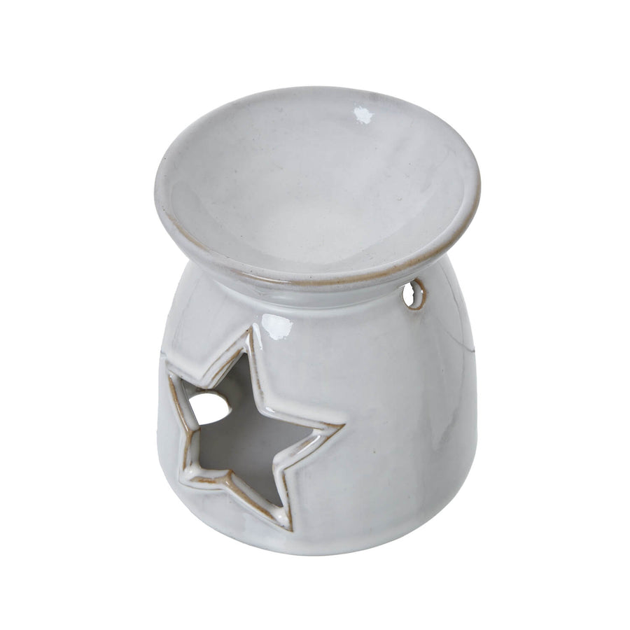 White ceramic tealight holder with star cut-outs casting intricate shadow patterns, perfect for wax melts or candles by Sostter at brixbailey.com