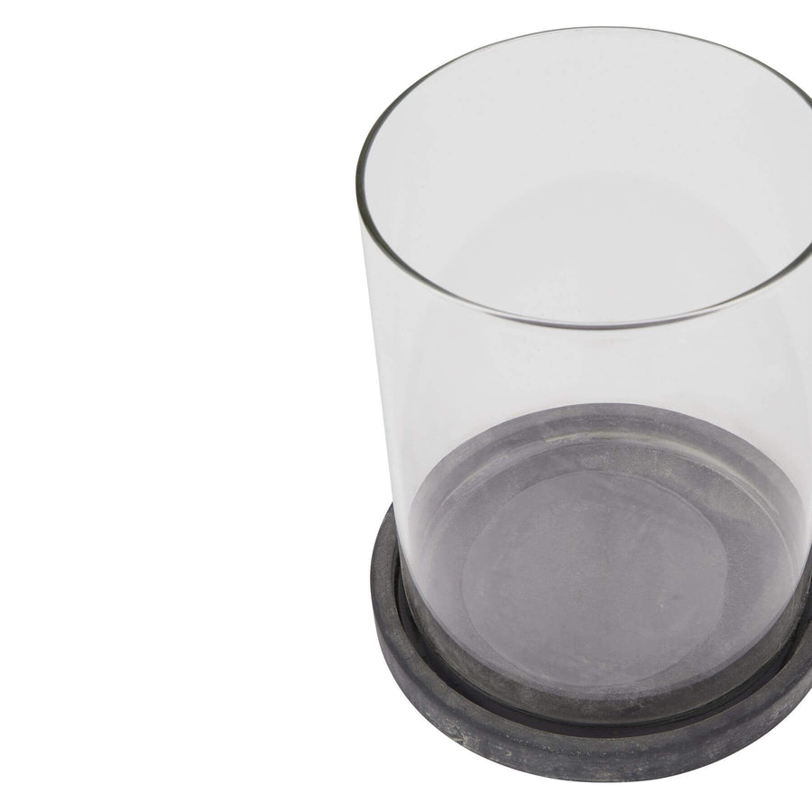 Grey ceramic hurricane lantern with glass panels, creating atmospheric candlelight glow for indoor or outdoor decor. by Hill Interiors at brixbailey.com