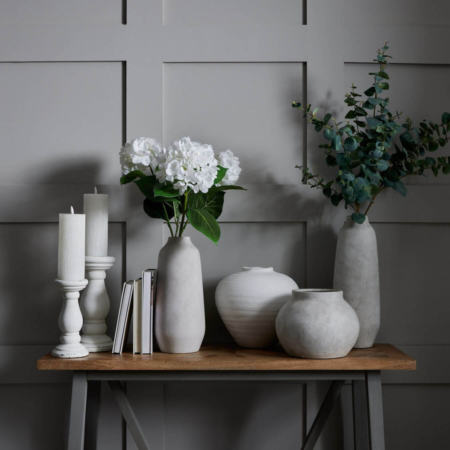 Minimalist white ceramic vase with sculptural silhouette, perfect for floral arrangements in modern decor. by Sostter at brixbailey.com