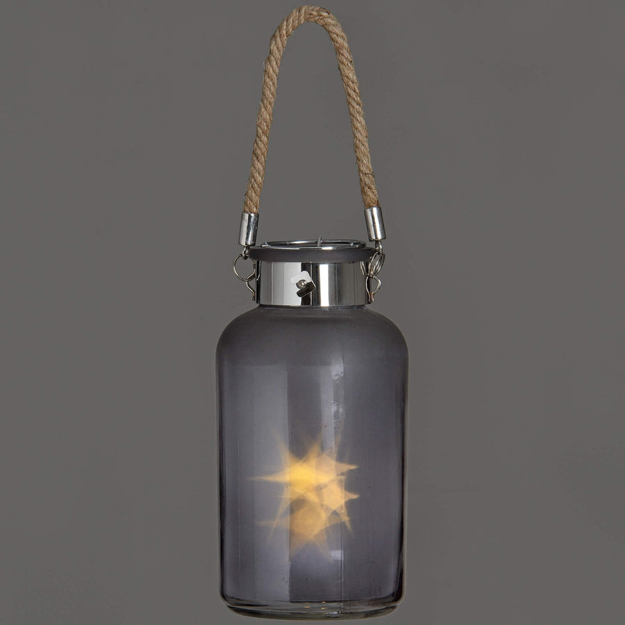 Frosted grey glass lantern with LED starlight glow, rope handle, and rustic modern design for indoor or outdoor ambiance by Sostter at brixbailey.com
