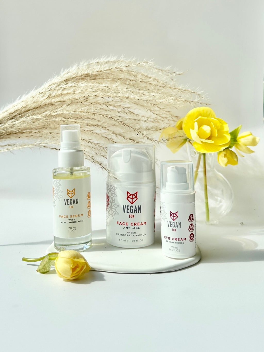 bold close-up of anti-age face care set with glowing serum bottle, fresh cream texture, and golden light