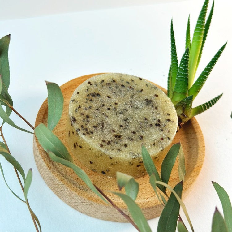 gentle kiwi seed body scrub bar with lemongrass scent on a soft linen towel, handmade in latvia