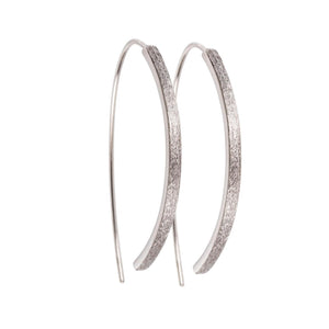 bold close-up of elegant small arch earrings with brushed silver texture and polished interior edge