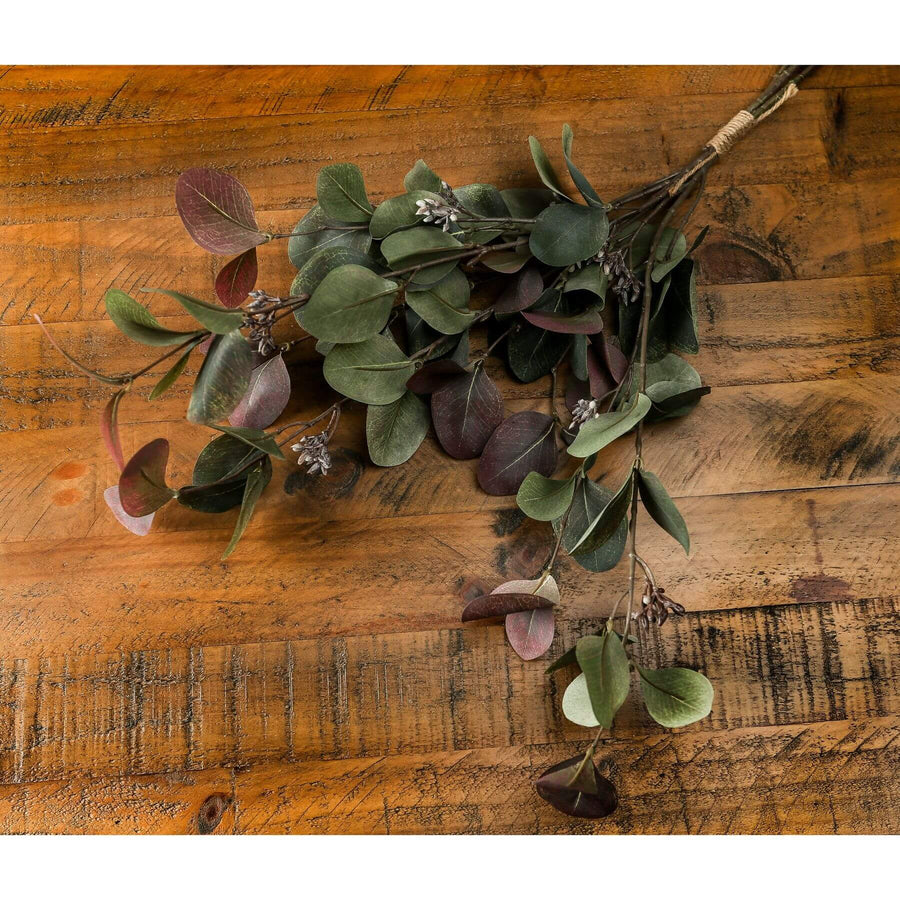 Hand-arranged eucalyptus bouquet with natural green leaves, grey tones, and ruby accents in a modern centerpiece. by Sostter at brixbailey.com