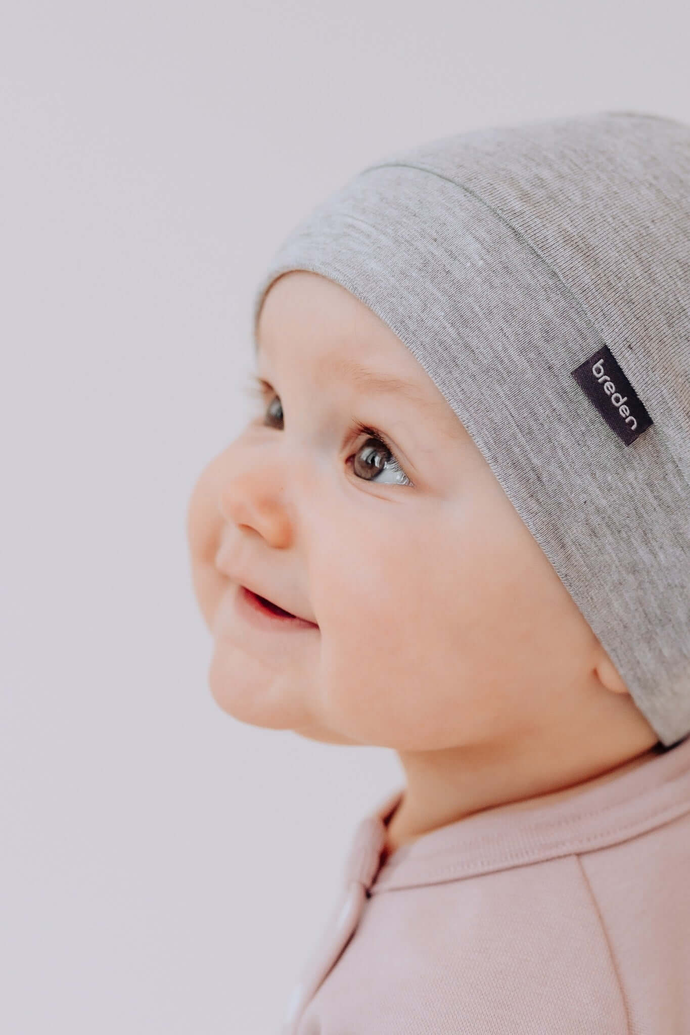 functional bamboo baby hat polly on a neutral background, showing its practical adjustable knot and soft texture