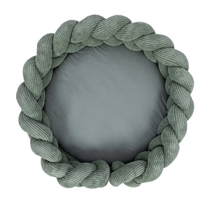 bold olive green baby nest with intricate braided bumper on a clean white background