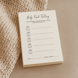 a soft-lit close-up of baby shower food tasting cards on a cozy linen tablecloth