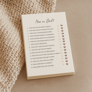 a soft-lit close-up of baby shower game cards on a cozy textile background