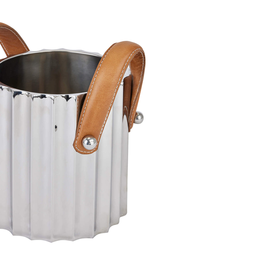 Silver fluted champagne cooler with stainless steel body and leather handles, reflecting elegant light for stylish entertaining. by Sostter at brixbailey.com