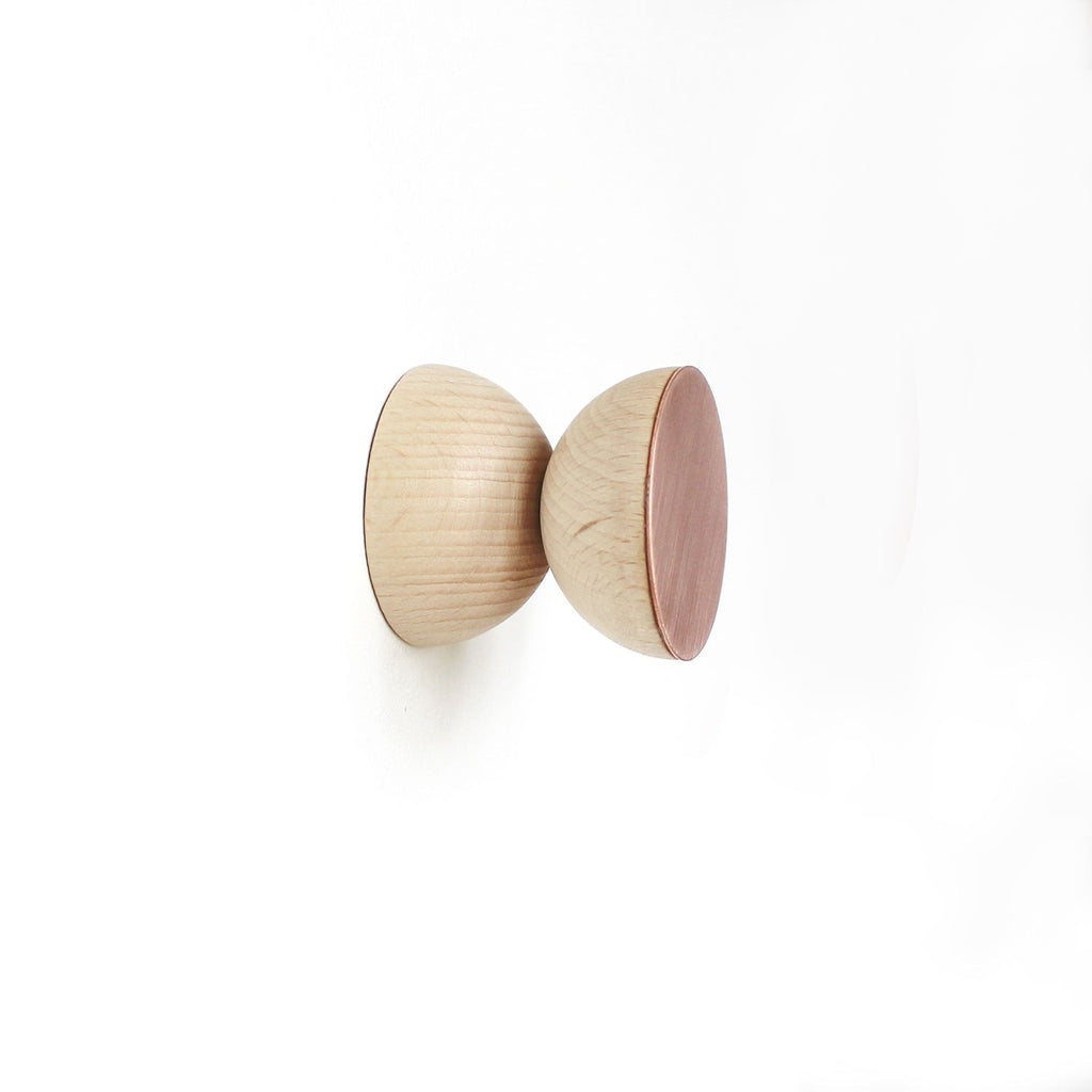 playful beech wood and copper wall hook on a bright yellow wall