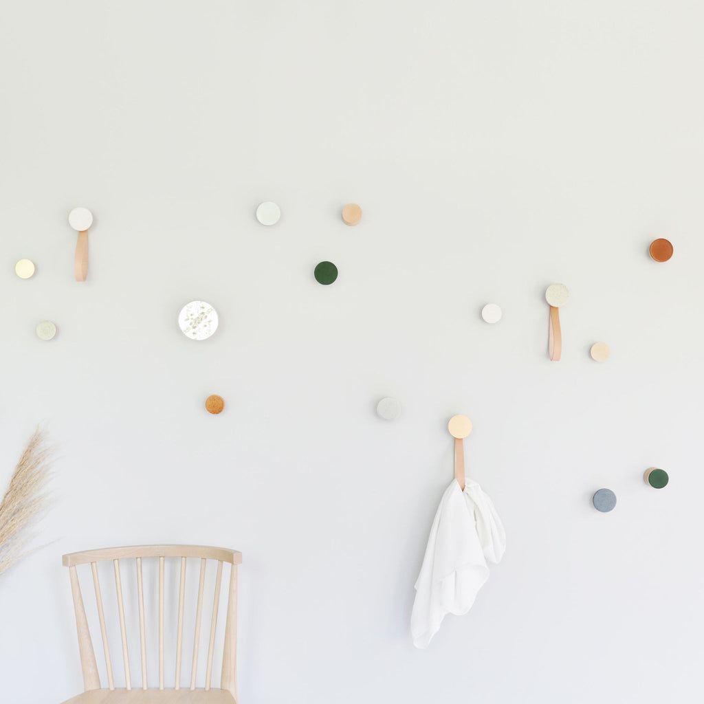playful dark terracotta ceramic hook with warm wood on a bright garden wall