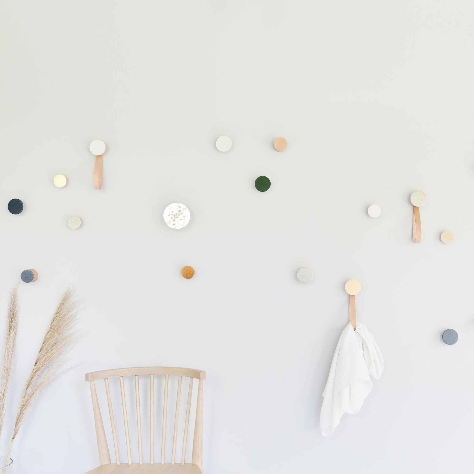 playful grey sand ceramic and beech wood wall hook in a bright, fun home setting