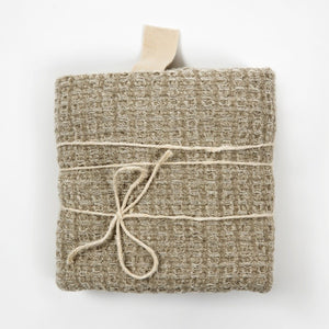 a soft grey linen bath towel draped gently, showcasing its comforting texture in warm, natural light