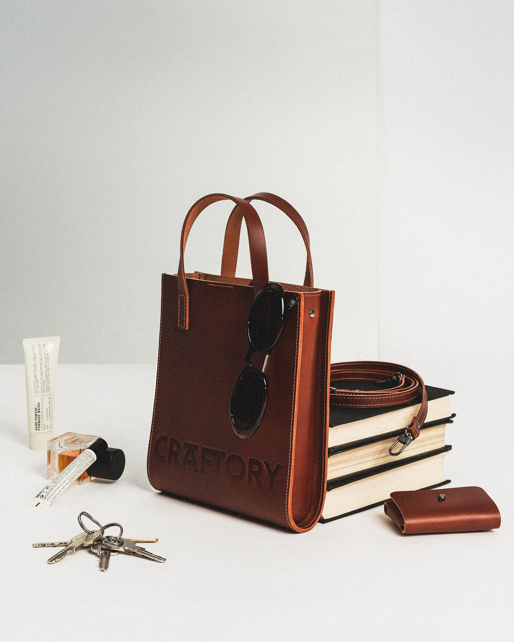 playful cognac bucket bag held by its handles against a bright, fun background