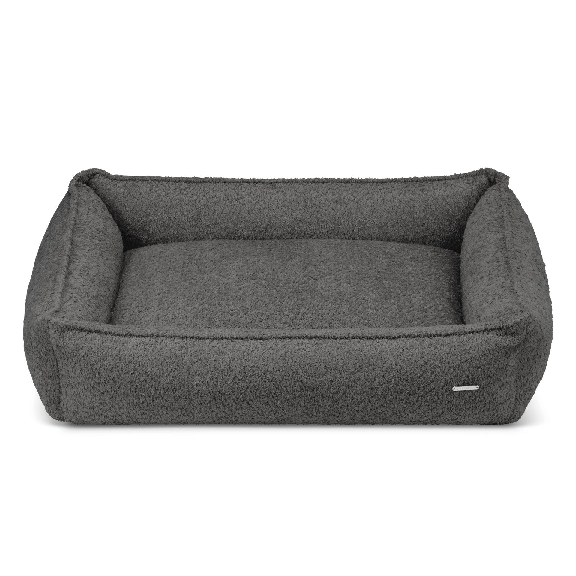 a confident dog lounging in a bold anthracite boucle bed with high sides