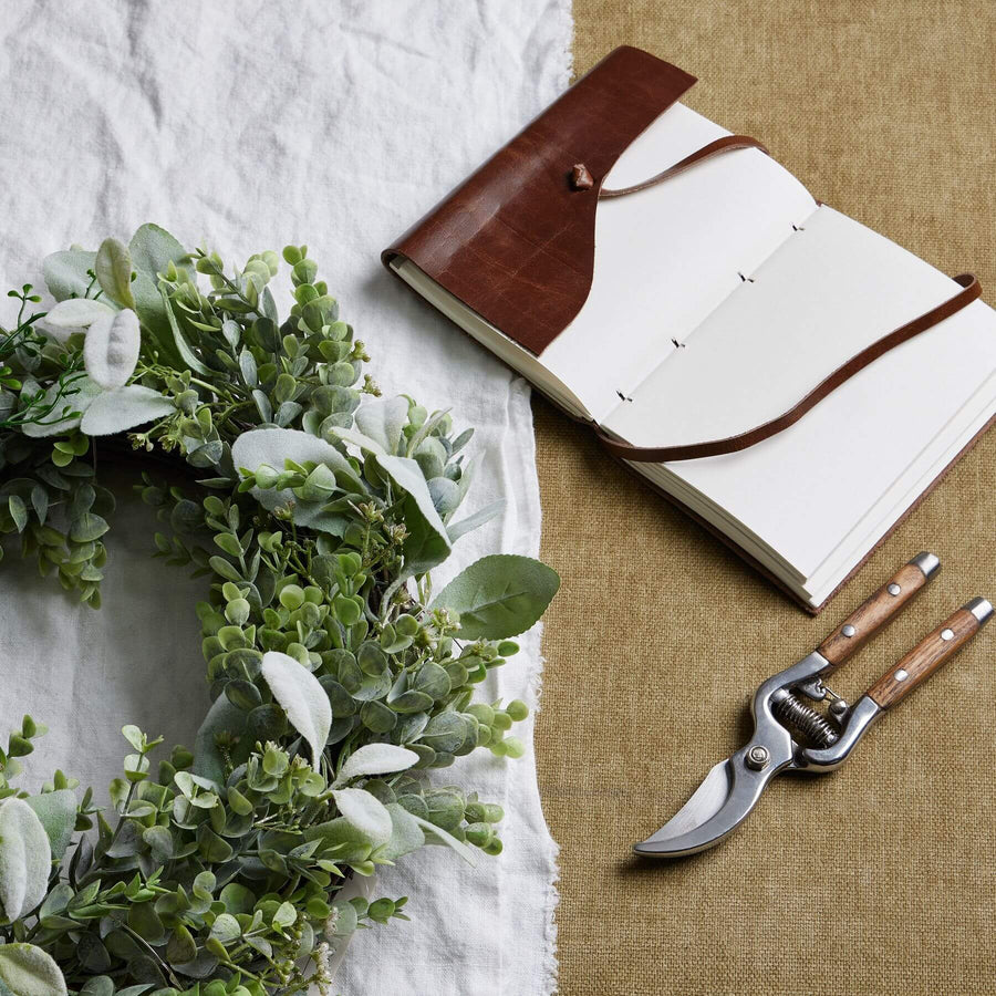 Handcrafted LED winter wreath with eucalyptus and lamb's ear foliage, glowing warm white lights, natural green and silver tones by Sostter at brixbailey.com