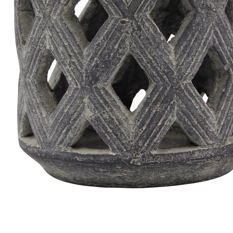 Grey ceramic lattice lantern with geometric Mediterranean patterns, casting intricate shadows when lit. by Sostter at brixbailey.com