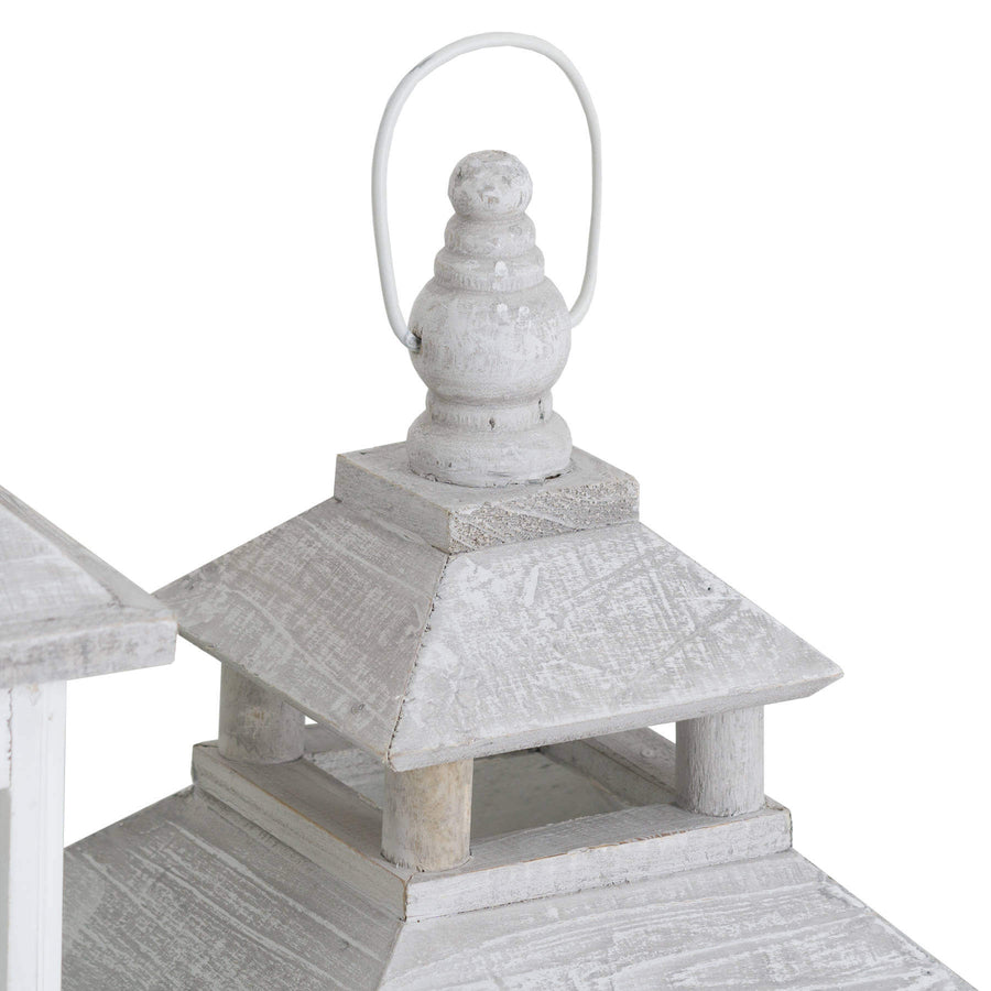 White wooden lantern with intricate window detailing, casting beautiful light patterns for coastal or Scandinavian decor. by Sostter at brixbailey.com
