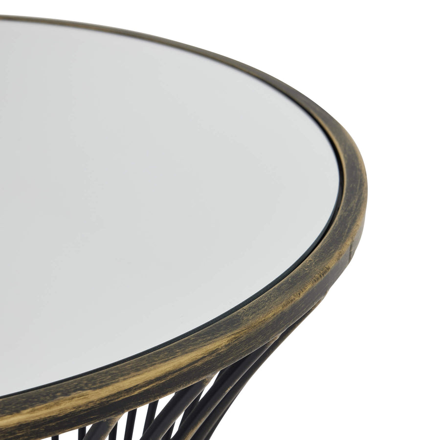 Handcrafted brass side table with black patina finish, mirrored glass top, and concave silhouette for modern interiors. by Sostter at brixbailey.com