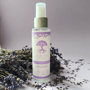 bold close-up of a 100ml lavender spray bottle with a dramatic mist against a dark background