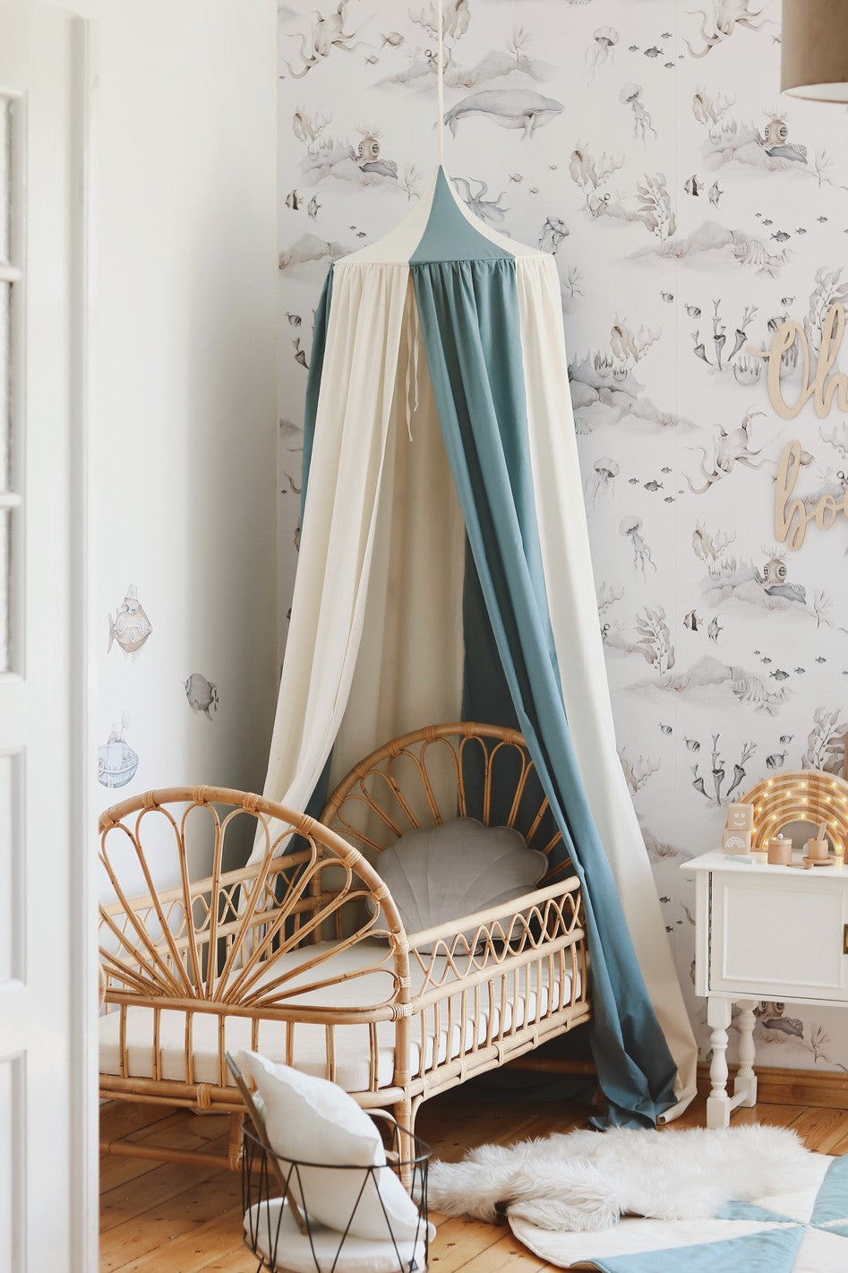 blue circus organic cotton canopy casting soft shadows on a child's reading nook