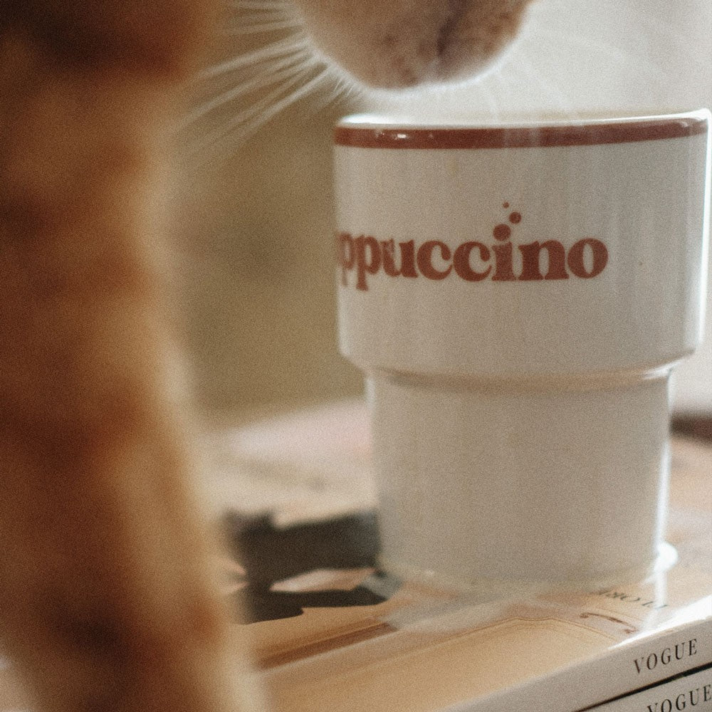 softly lit ceramic cappuccino mug with a comforting warm glow on a rustic table