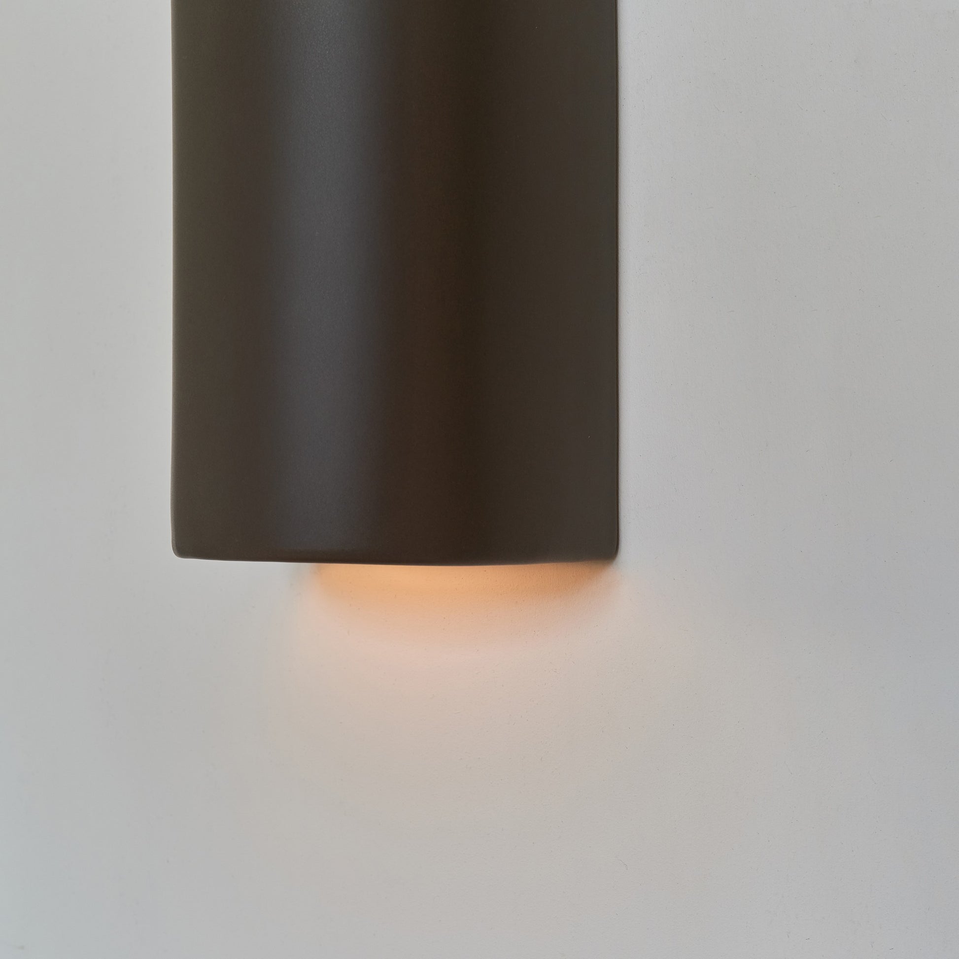 playful warm brown ceramic wall light casting a fun, cozy glow in a whimsical kids room