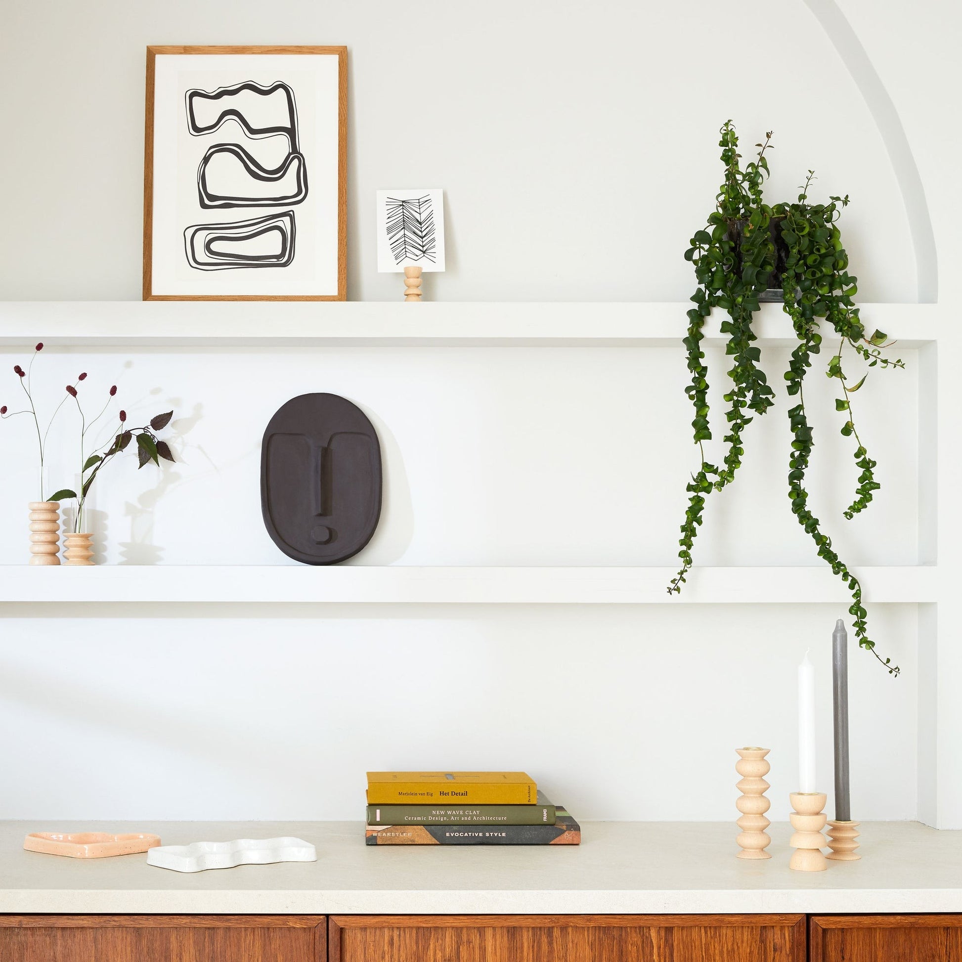 functional ceramic wall mask in matte terracotta orange, hung solo on a neutral wall for minimalist decor
