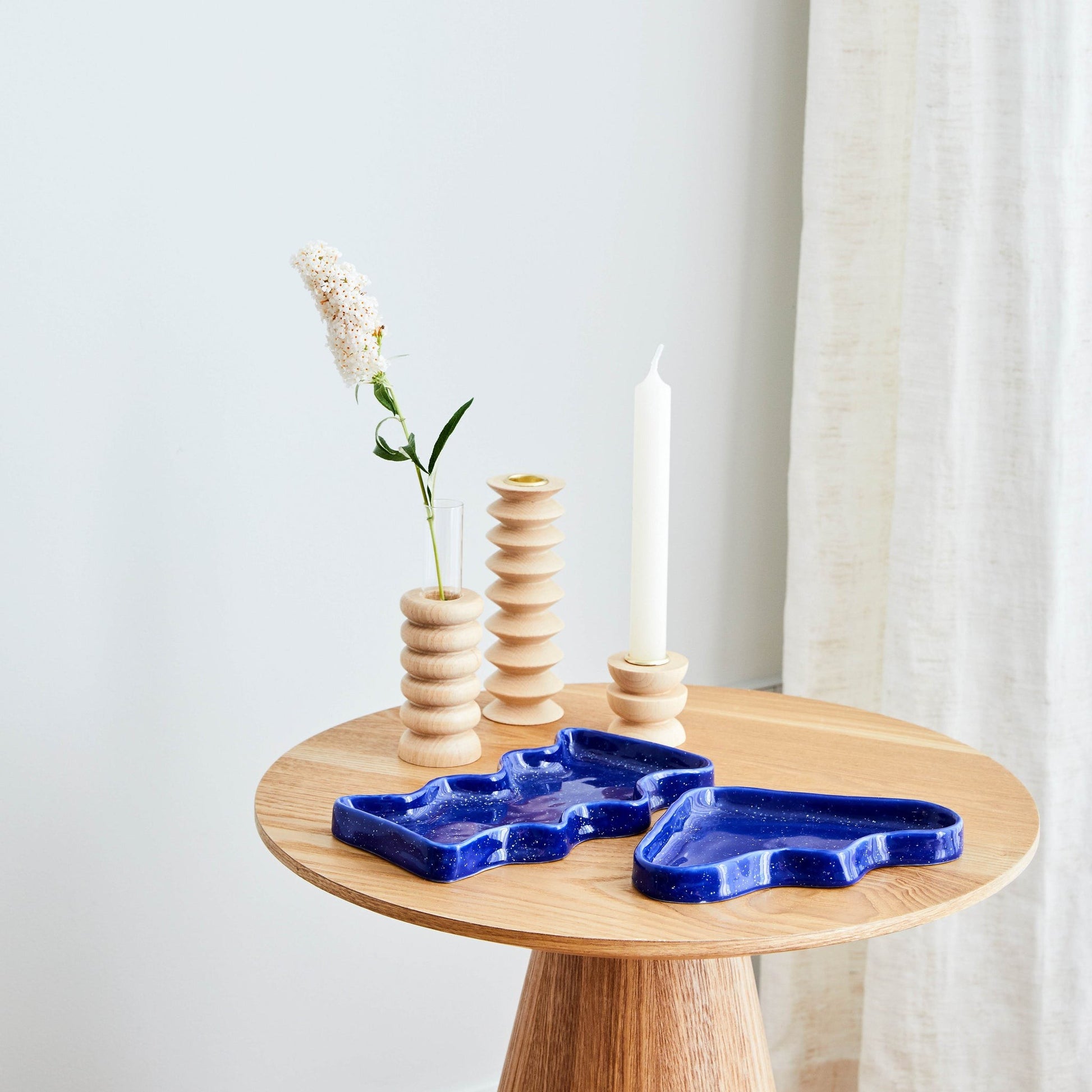 elegant blue ceramic wave tray with speckled glaze, resting on a marble surface in soft natural light