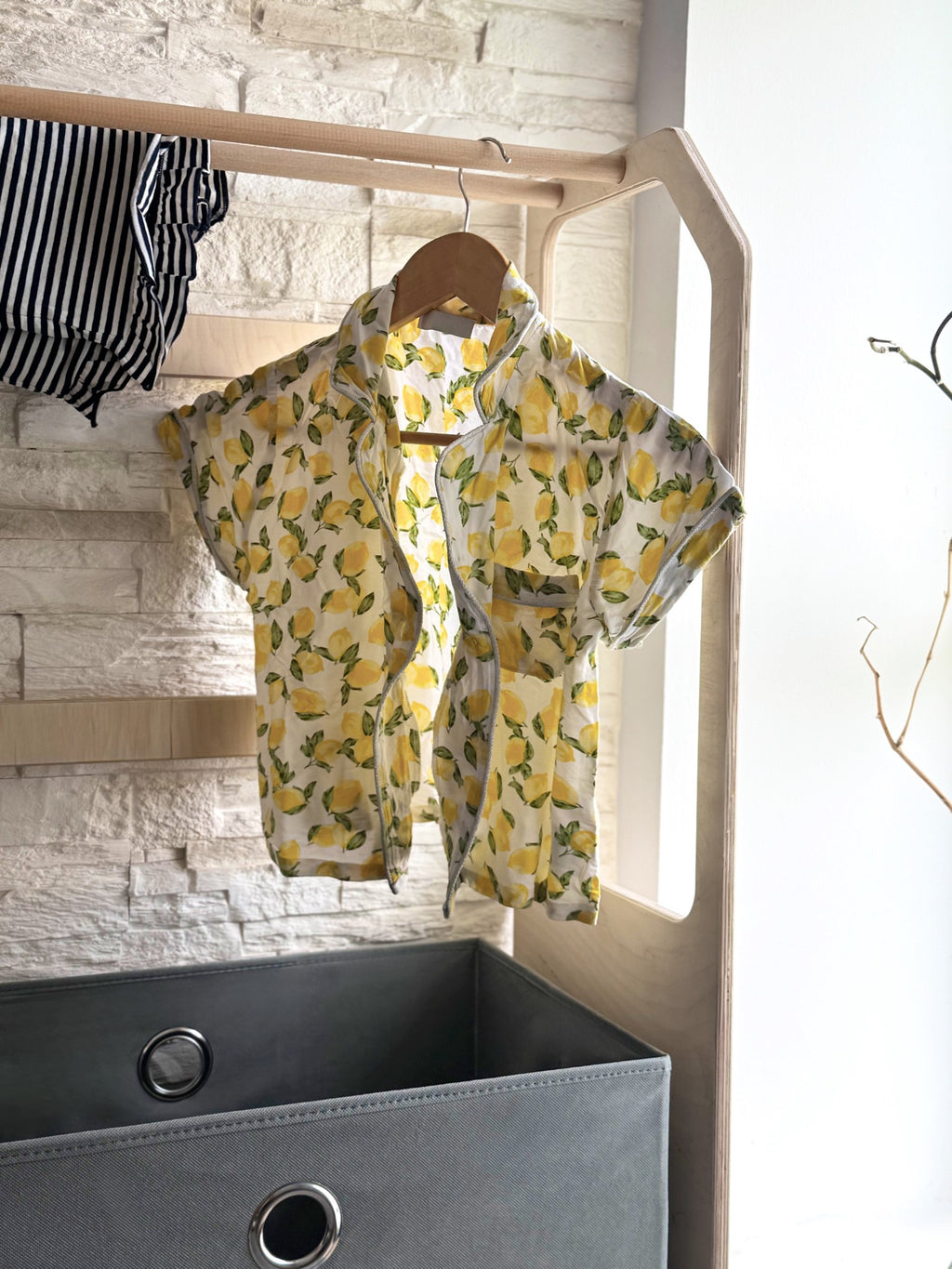a child's montessori drying rack with a grey fabric basket in a soft, natural morning light
