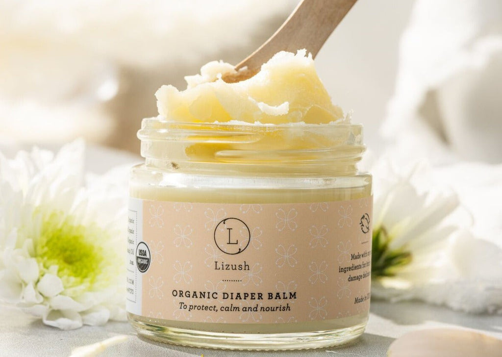 practical layout of organic baby gift set contents - balm, powder, and bib on a clean surface