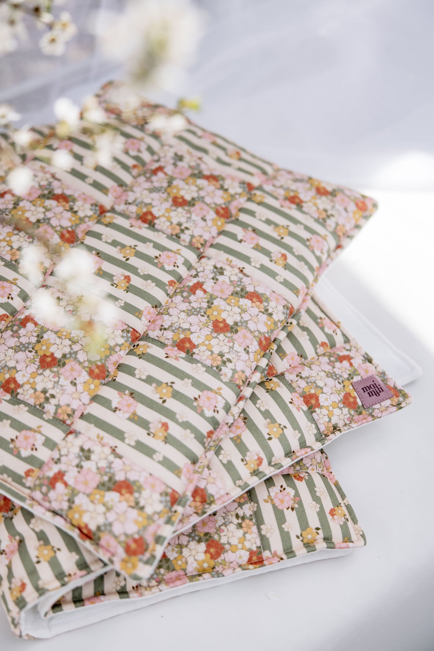 playful green garden quilted blanket and pillow set laid out on a sunny nursery floor, ready for cozy naps