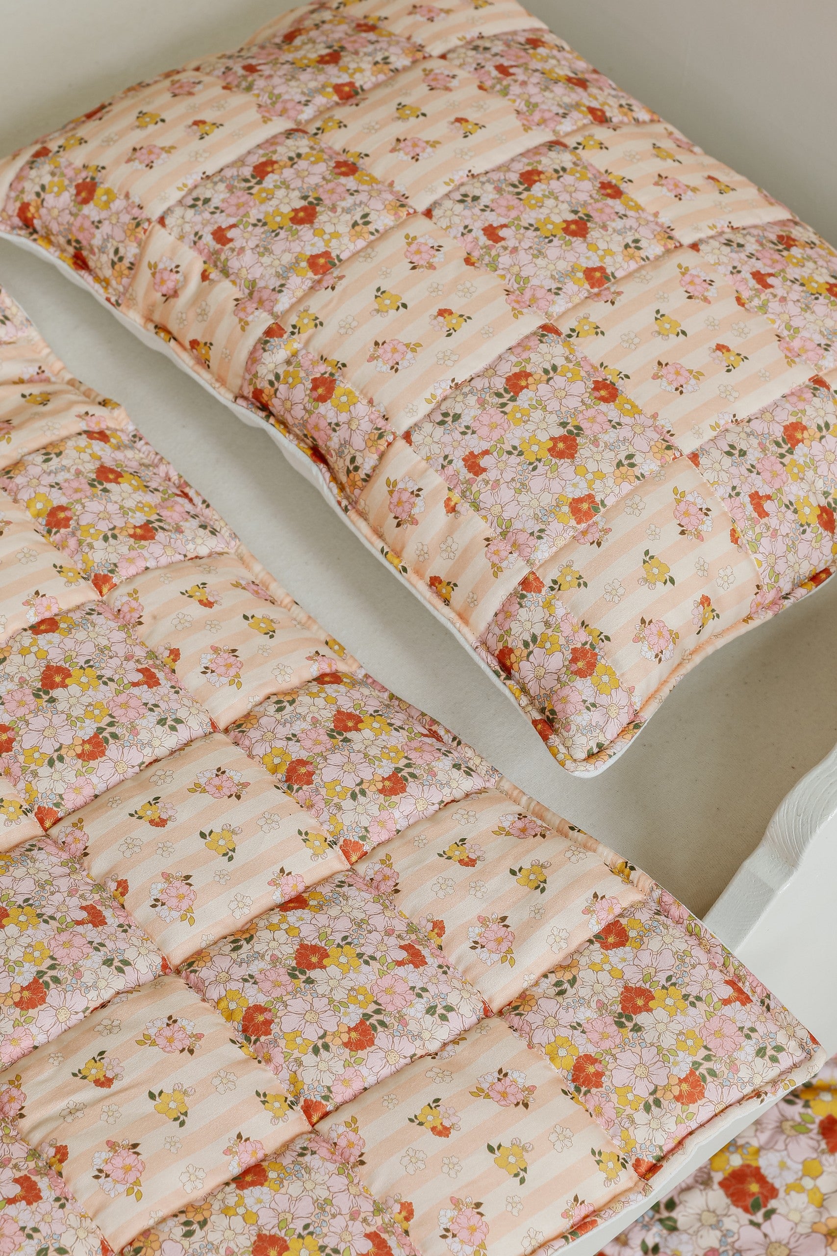 functional cotton quilted patchwork blanket and pillow set small - spring garden, laid flat on a wooden floor for easy viewing