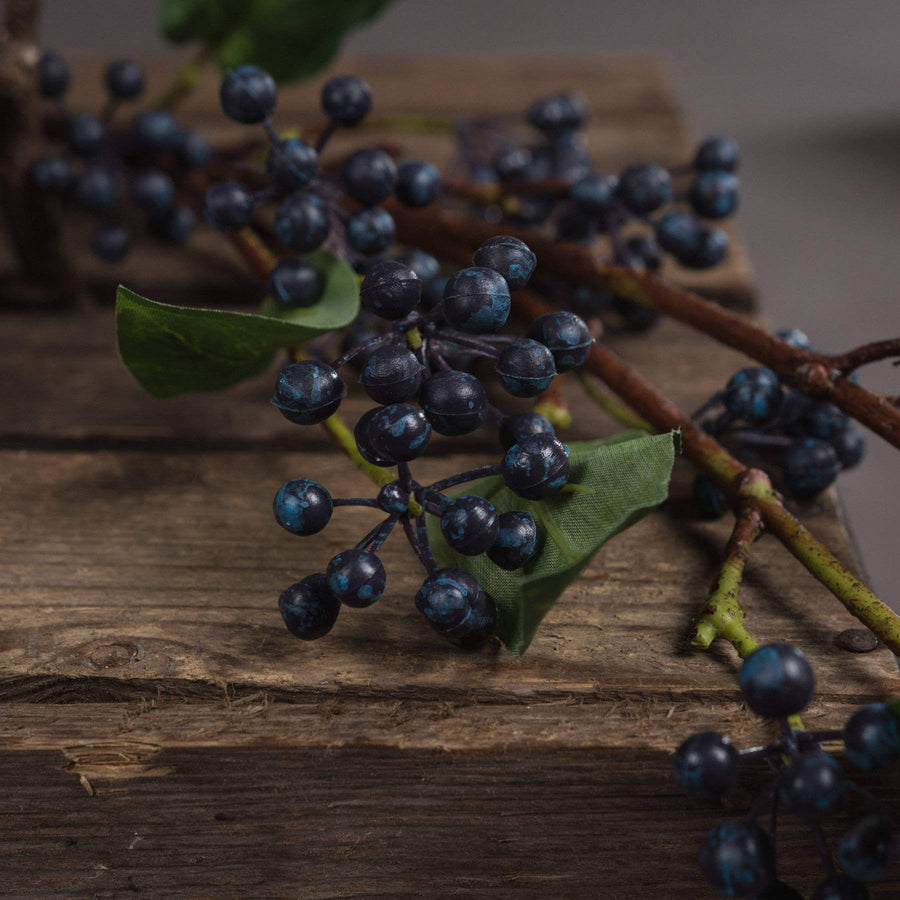 Handcrafted indigo berry stems with deep blue hues, realistic texture, and flexible wired branches for elegant floral arrangements. by Sostter at brixbailey.com