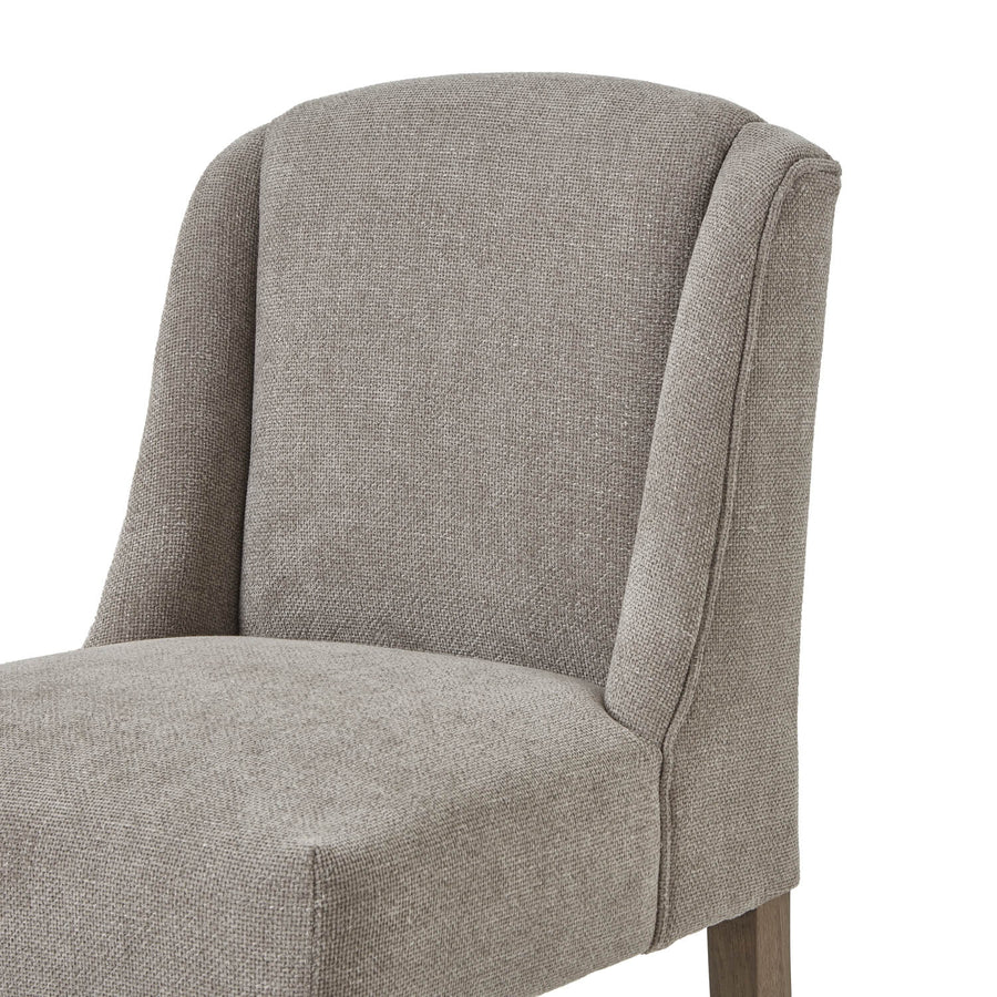 Handwoven taupe dining chair with solid wood frame, ergonomic curved silhouette, and dark wood accents. by Sostter at brixbailey.com