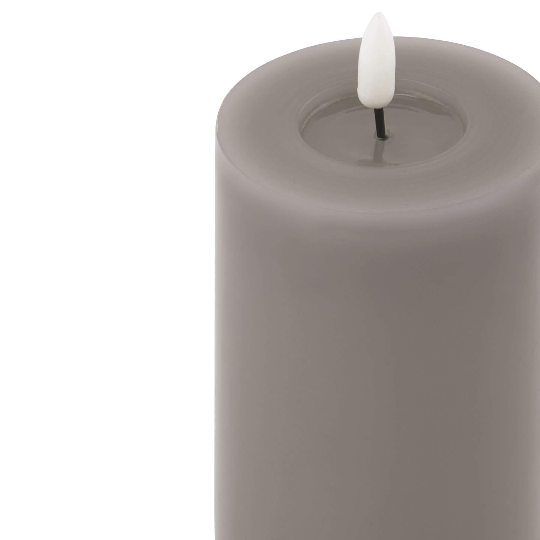 softly glowing grey led candle with a gentle melt effect, casting a warm comforting light in a cozy room